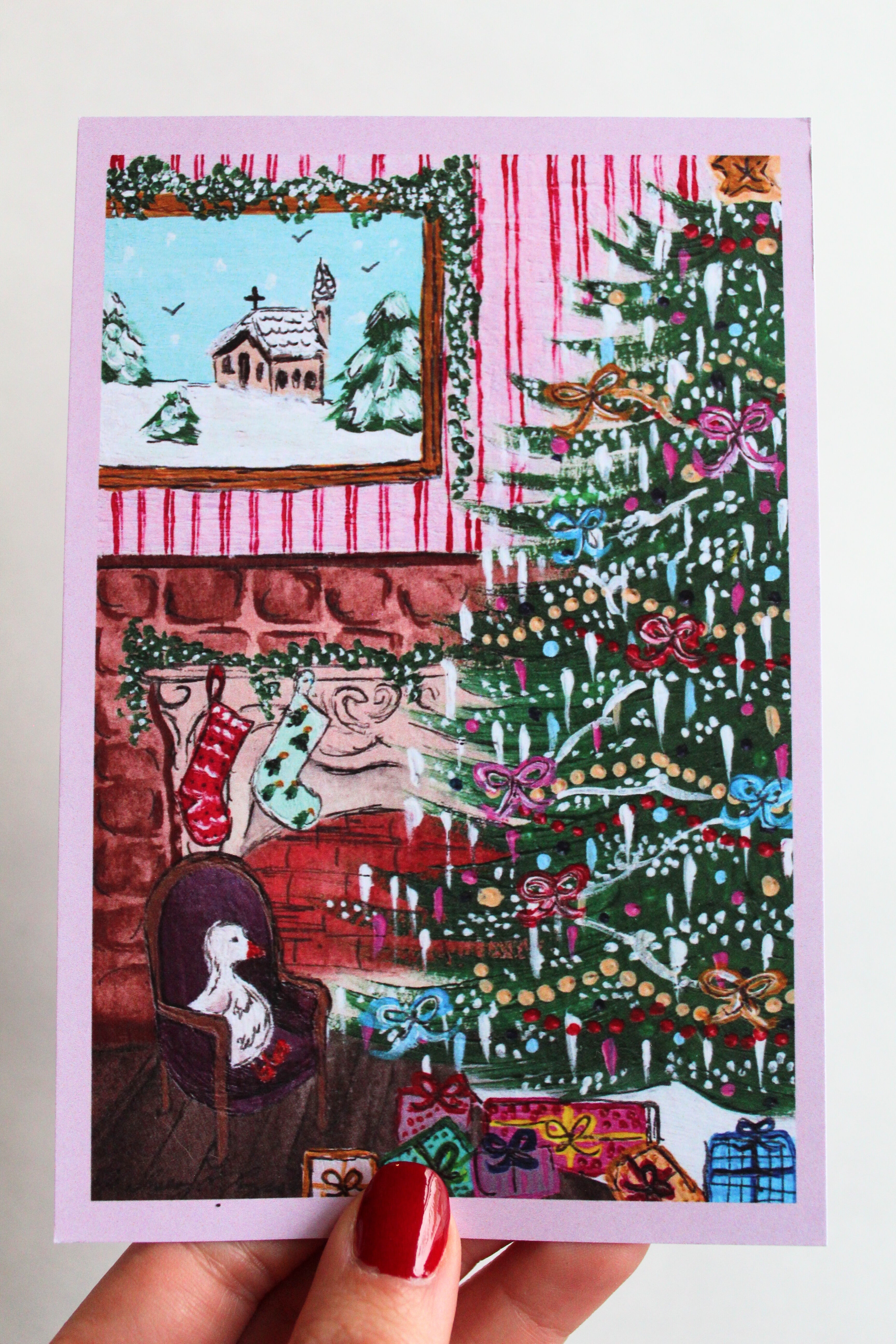 Postcard with an illustration of a duck sitting in a chair beside a decorated Christmas tree and presents.