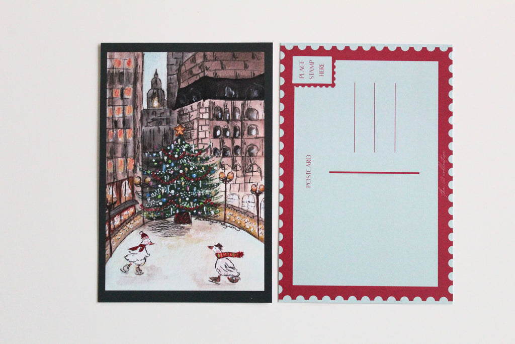 Postcard with an illustration of two ducks skating in front of a Christmas tree, wearing hats and scarves, in front of a city landscape. Pictured with the back of the postcard where a letter can be written and address lines.