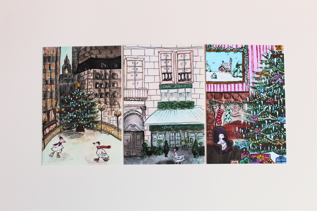 All three horizontal postcards. The first of the "Christmas in New York" postcard, "Duck in Paris" postcard, and "A Very Merry Christmas" postcard.