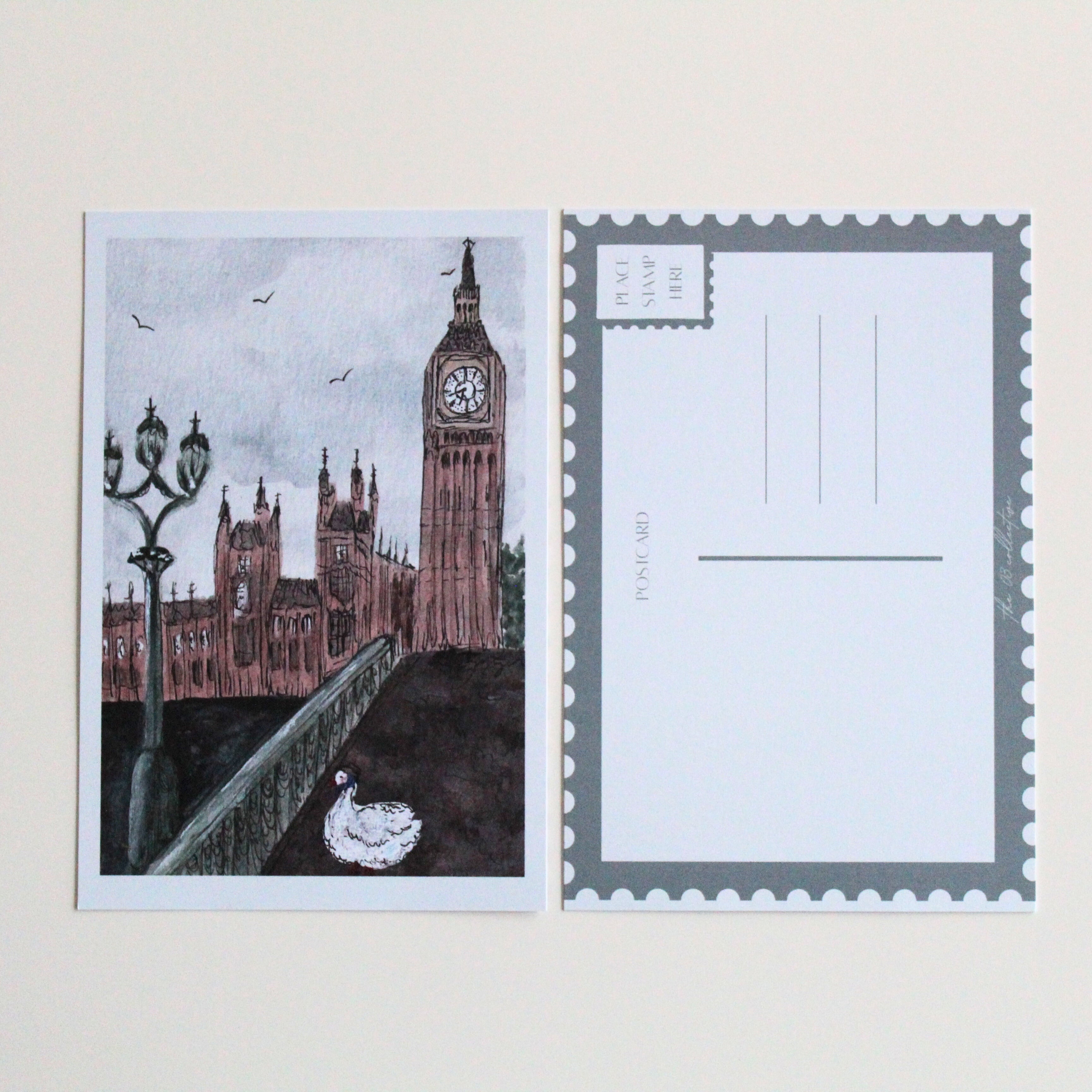 Postcard with an illustration of a duck in London, wearing a blue scarf and brown hat, walking on a bridge in front of Big Ben and Parliament. Pictured with the back of the postcard where a letter can be written and address lines. 