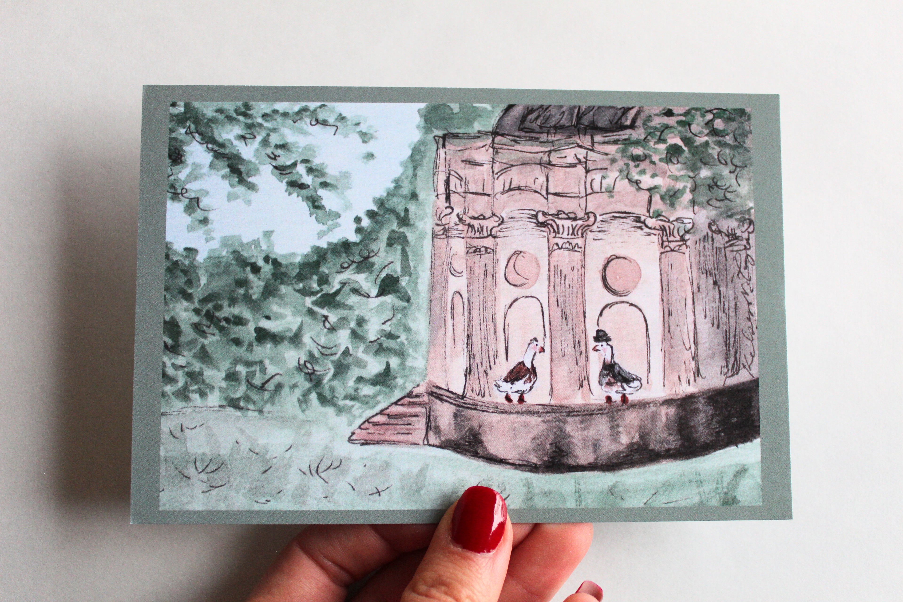 Postcard with an illustration of two ducks at the Temple of Apollo, one wearing a dress, and the other wearing a suit and hat, surrounded by leaves and trees.